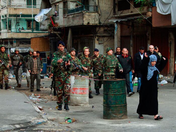 

Mulher gesticula enquanto passa no meio do exército
libanês, após um conflito entre muçulmanos sunitas e alauítas em Trípoli