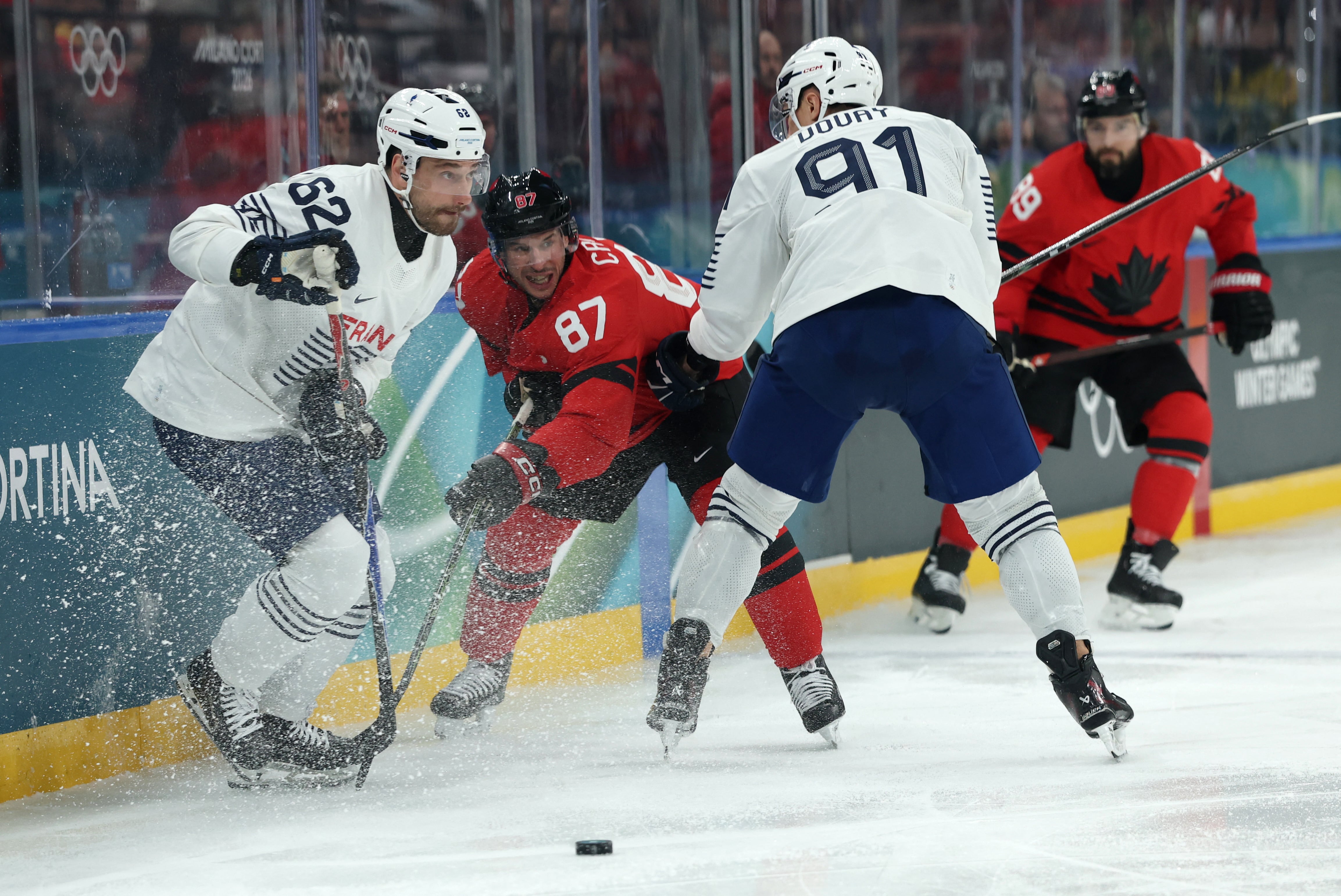 Dois atletas da França disputam disco de hóquei com dois atletas do Canadá