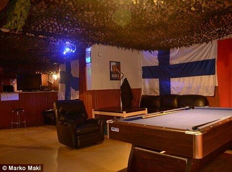 O teto está coberto por uma rede de camuflagem e grandes bandeiras finlandesas cobriam as paredes. São indícios de uma espécie de Partido Nazista Finlandês