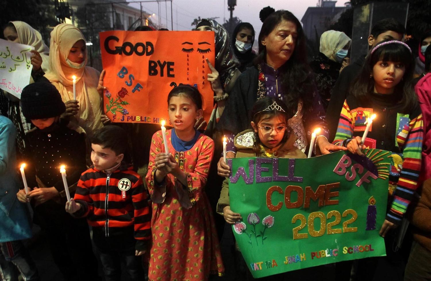 Students hold candles during a rally to pray for peace in year 2022 on New Year's Eve in Lahore, Pakistan, 31 December 2021.