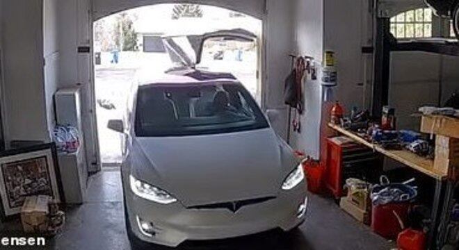 Momento em que a porta do Tesla fica presa na parede da garagem