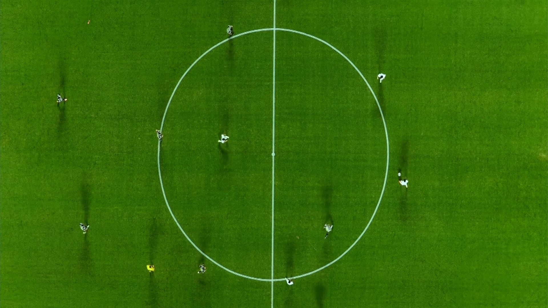 Campo de futebol visto de cima, com jogadores