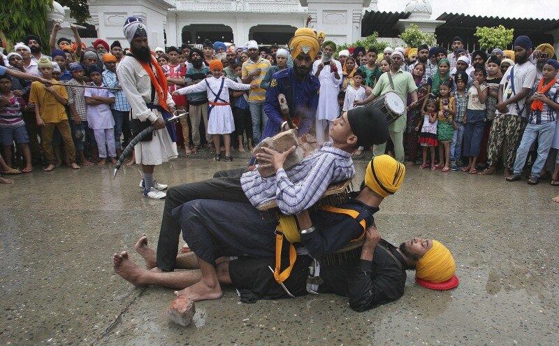 Guerreiro nihang ou sikh usa martelo
para quebrar tijolos em cima do estômago de outro sikh em apresentação de Gatkha,
uma arte marcial tradicional, durante as celebrações do 410º aniversário do livro
sagrado para a religião sikh na Índia