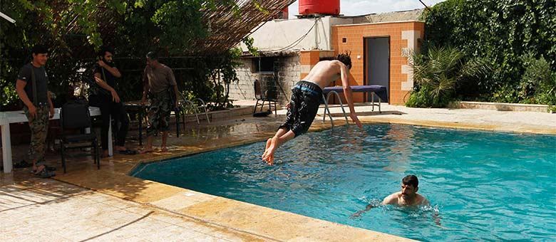 Membros do Exército Livre da Síria aproveitam descanso em piscina em Aleppo