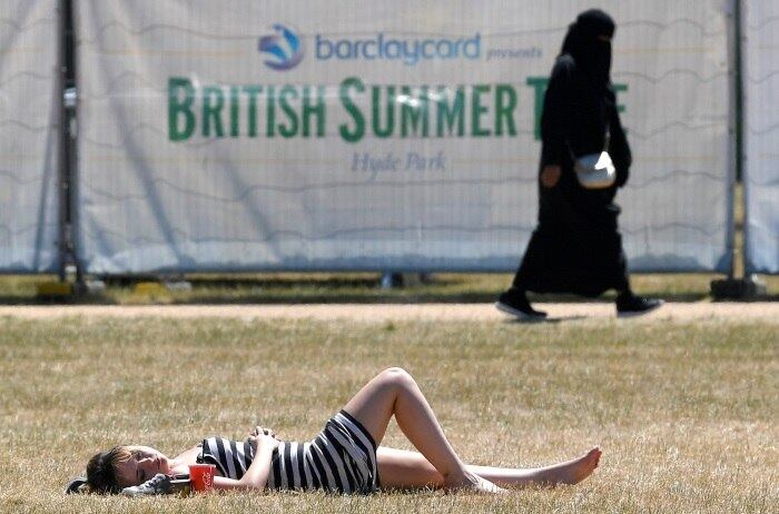 Na gelada Londres, uma mulher britânica aproveita o período de sol