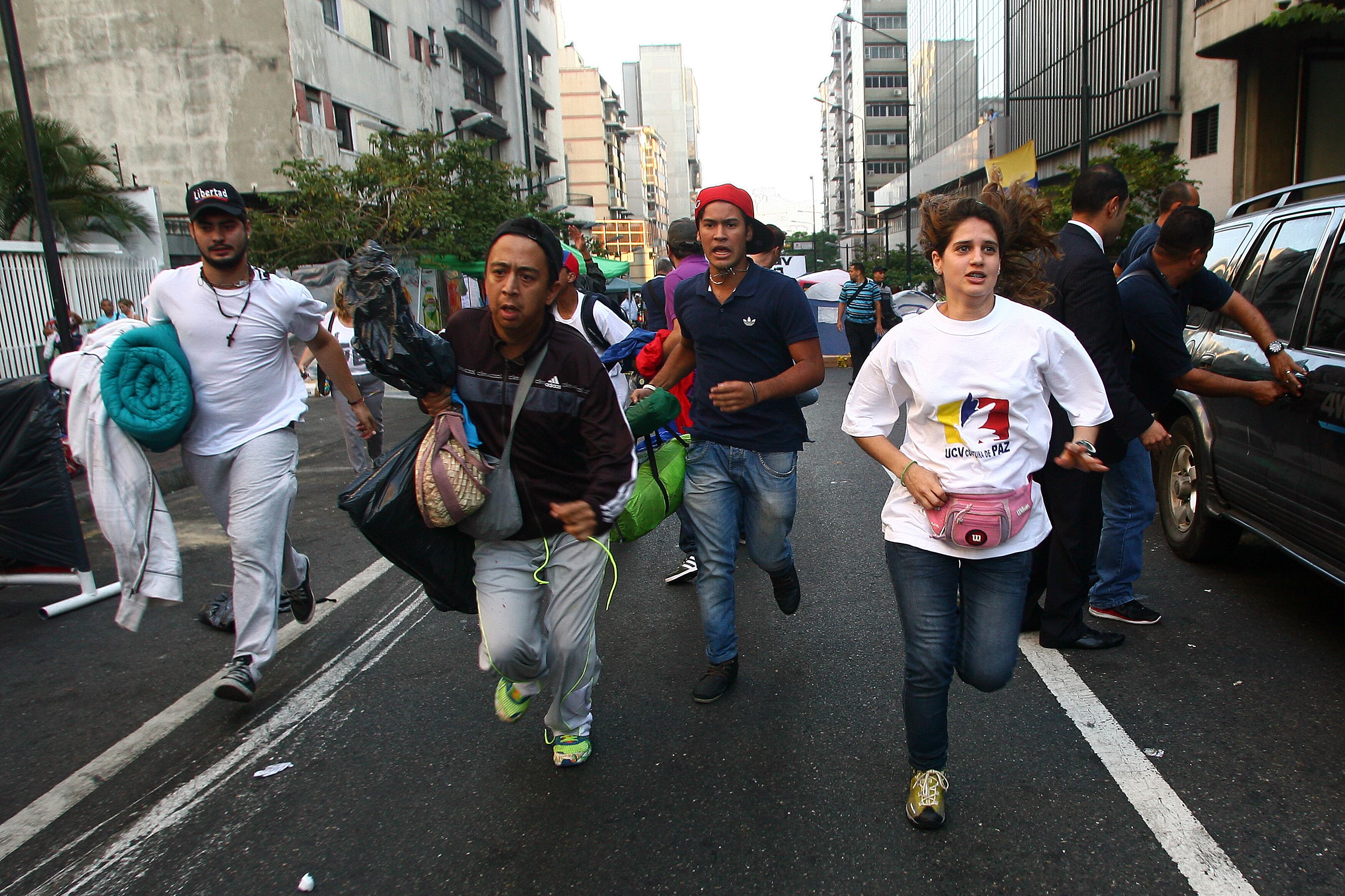 Oposicionistas que faziam protesto para saber a verdade sobre a saúde de Chávez correm depois de ouvirem a notícia da morte do presidente