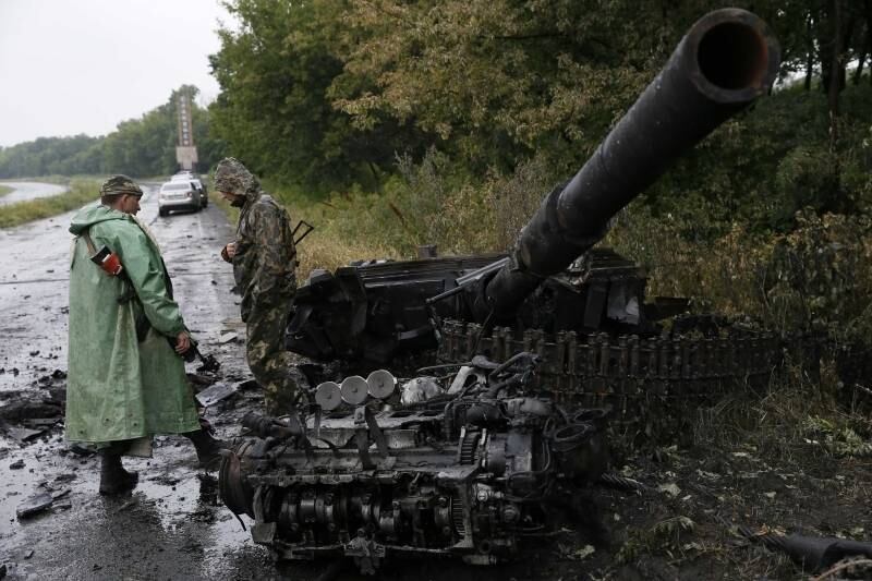 Tropas ucranianas
inspecionam veículo militar destruído próximo à cidade de Slaviansk, no leste
da Ucrânia