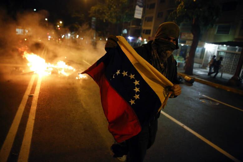 Nesta outra imagem, um protestante oposicionista ao governo de Nicolas Maduro carrega a bandeira da Venezuela durante as manifestações que tomaram o centro da capital Caracas na noite desta sexta-feira (14)
Veja as notícias pelo mundo em R7.com/internacional