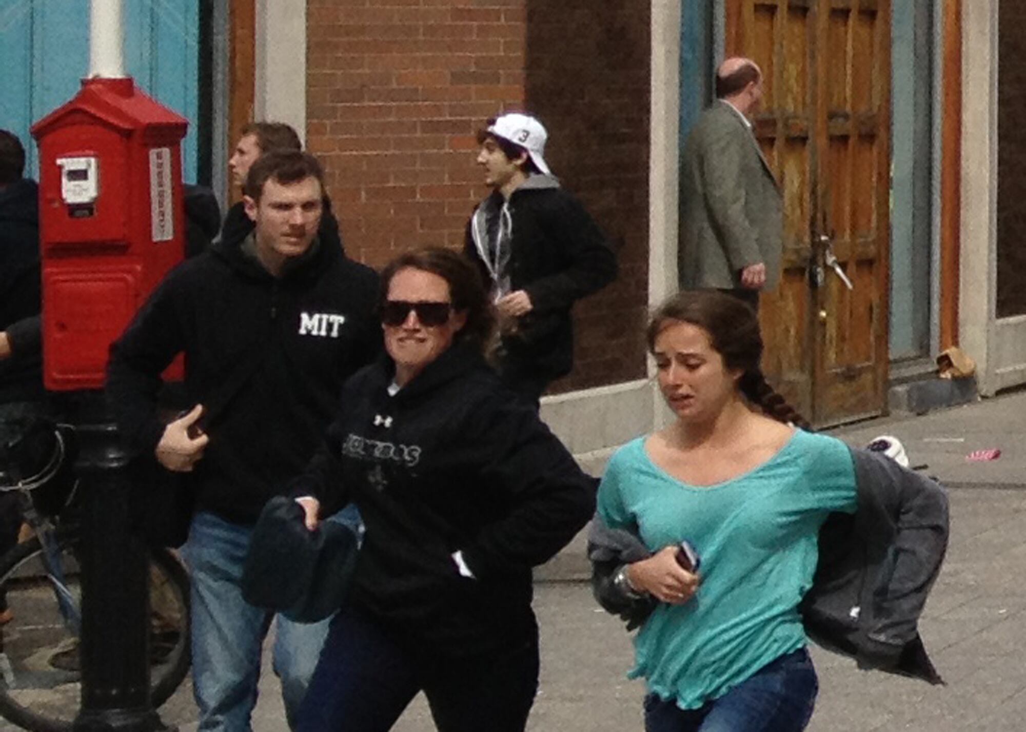 Acima, Dzhokhar Tsarnaev aparece de boné branco correndo após as explosões; jovens em primeiro plano mostram desespero
