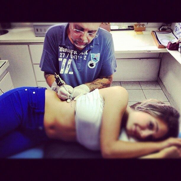 A beldade tem uma tattoo na costela. Sorte do tatuador...