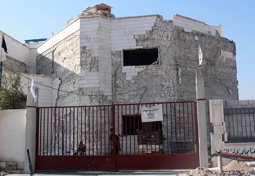 Acima, rebeldes fazem guarda em frente ao quartel da Al Qaeda, capturado hoje. Antes da guerra civil, o local funcionava como um hospital em Aleppo