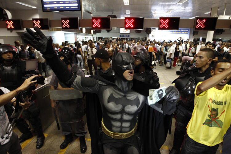 Eron Melo se tornou famoso no Rio ao participar de quase todos os protestos de rua a partir de junho de 2013. Ao R7, ele explicou a caracterização:

— Eu uso a fantasia do Batman como símbolo de esperança, heroísmo, luta contra a injustiça. Estou desde junho nas ruas. Estive nas manifestações contra o aumento da passagem, na favela do Metrô e agora nos protestos dos alunos da Gama Filho.
Leia mais

