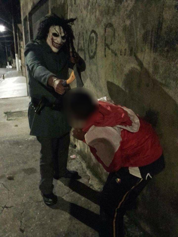 Travestido com máscara do Coringa, PM ameaça jovem com machado e pistola .40
