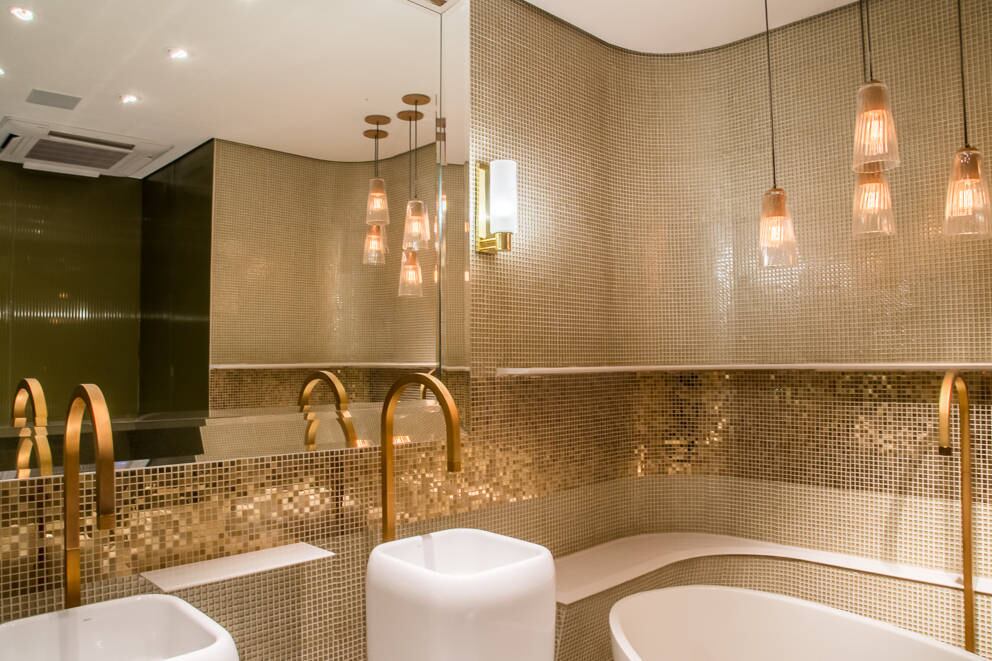 Com torneiras douradas, luminárias suspensas no teto e grandes espelhos, o banheiro feminino possui até uma banheira. No entanto, de acordo com a assessoria da empresa que patrocina o local, não haverá condições de encher a peça de água