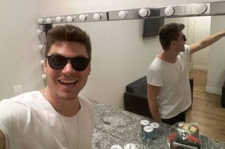 Cantor faz selfie sorridente nos bastidores do Domingo Show