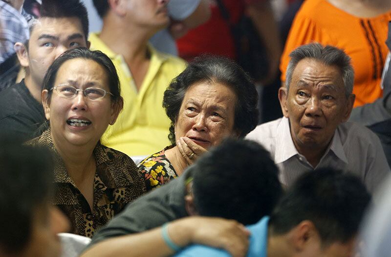 Familiares de vítimas do voo da AirAsia acompanham a cobertura da TV local durante o resgate. As autoridades indonésias confirmaram que encontraram no mar de Java as partes do Airbus 320-200 da AirAsia que se acidentou com 162 pessoas a bordo