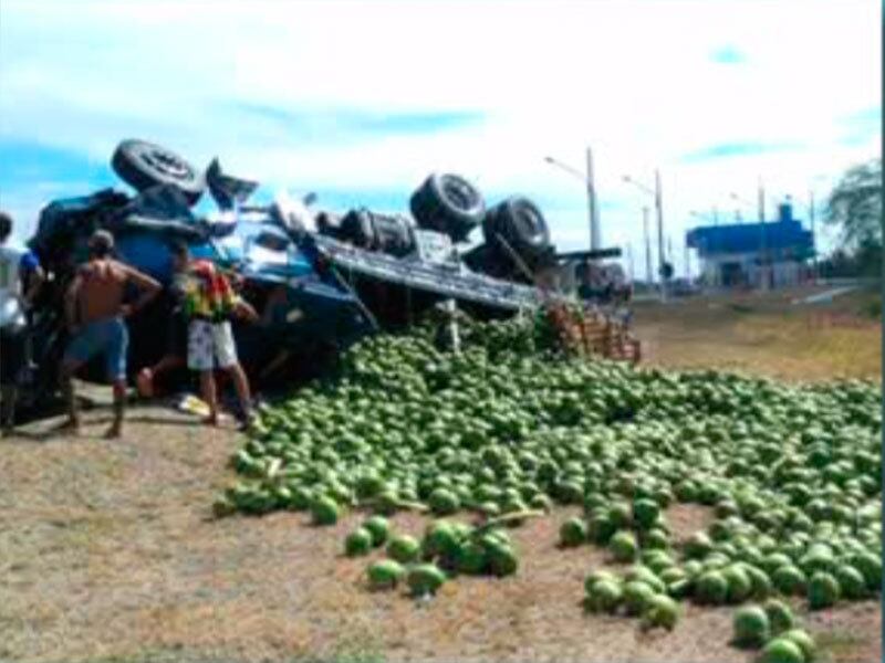 A carga de coco ficou espalhada pela pista e o carro de passeio ficou parcialmente destruído