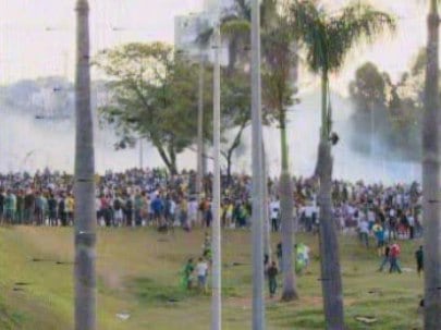 Um carro de
som orienta os manifestantes a se manterem longe da barreira de
proteção. Jovens isolados do grupo avançam e investem com pedras contra a
polícia, que responde com bombas
