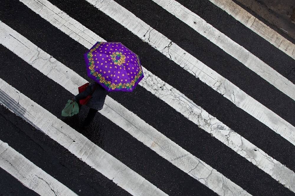 Pedestres enfrentam chuva forte em Santana, na zona norte da capital 