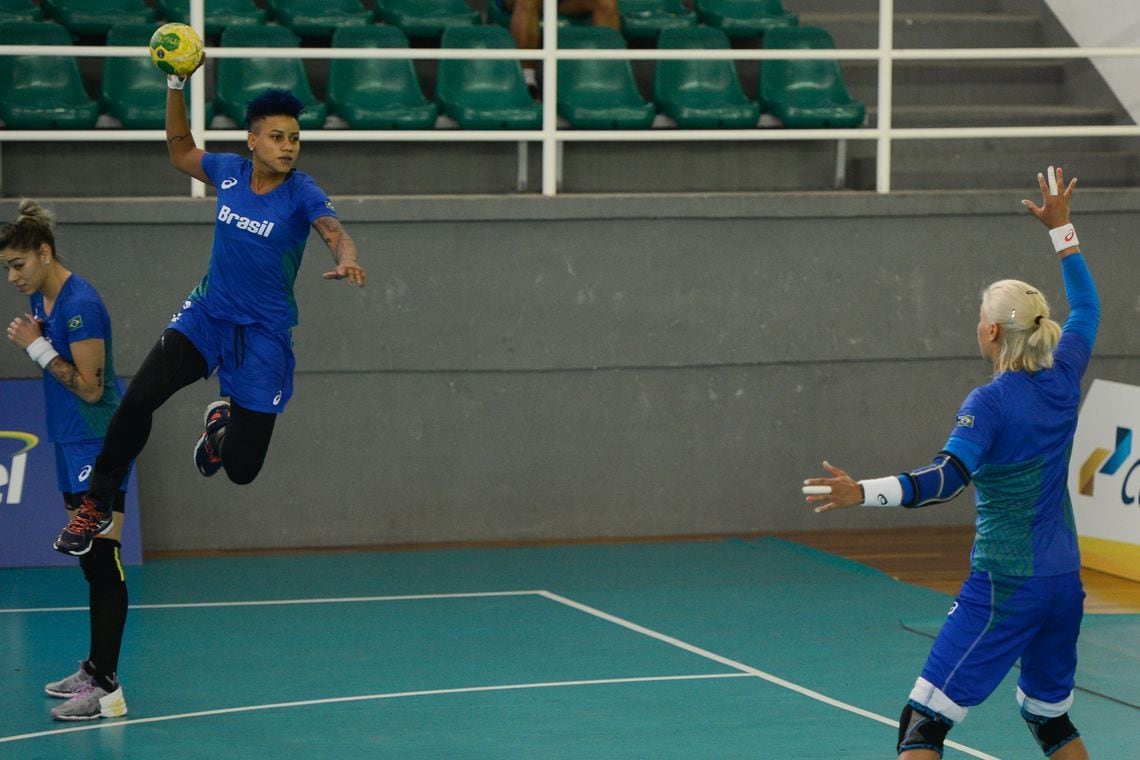 Atletas praticam handebol em quadra poliesportiva