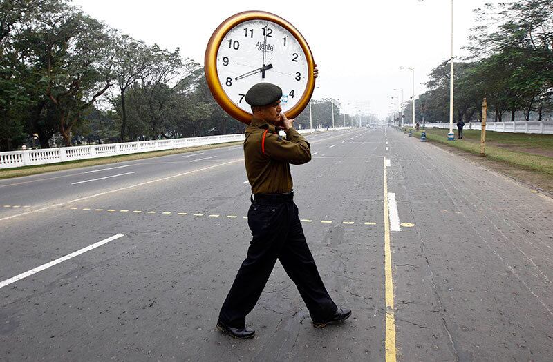 Neste domingo (4), soldado do Exército da Índia atravessa rua com um relógio de parede que será afixado, temporariamente, para monitorar o tempo de um desfile militar, em um ensaio para o Dia da República em Kolkata. A Índia celebra o Dia da República no dia 26 de janeiro