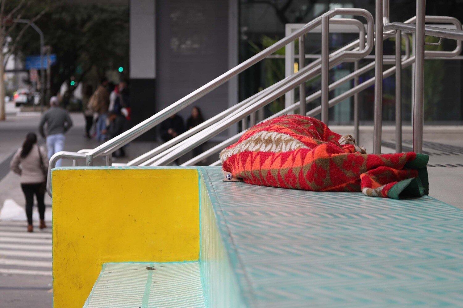 Morador de rua se protege do frio na Avenida Paulista na manhã deste sábado (3)
