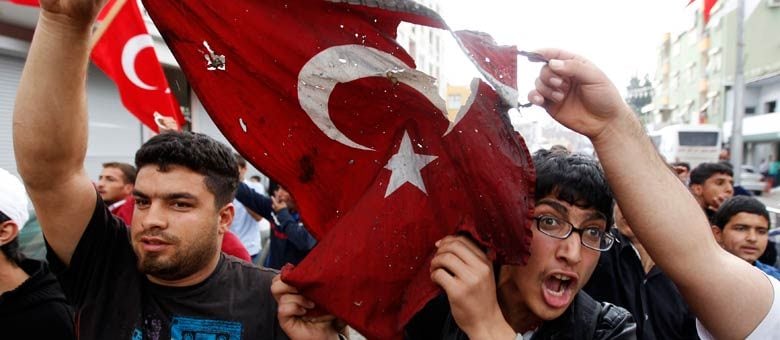 Manifestantes turcos queimam bandeira nacional durante protesto contra a política do governo da Turquia em relação a Síria