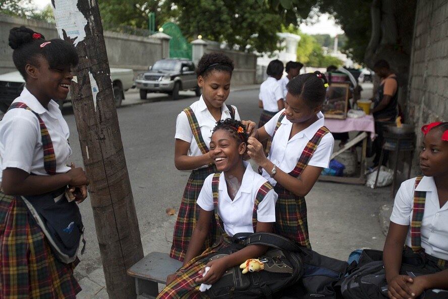 Meninas se enfeitam para seu primeiro dia de aula, nesta segunda-feira (8), no Haiti. Em frente a escola pública Lycée Marie Jeanne, elas se ajudam nos penteados de cabelo e usam perfumes 