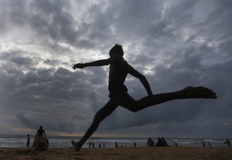 Meninos jogam futebol em praia
de Colombo, no Sri Lanka