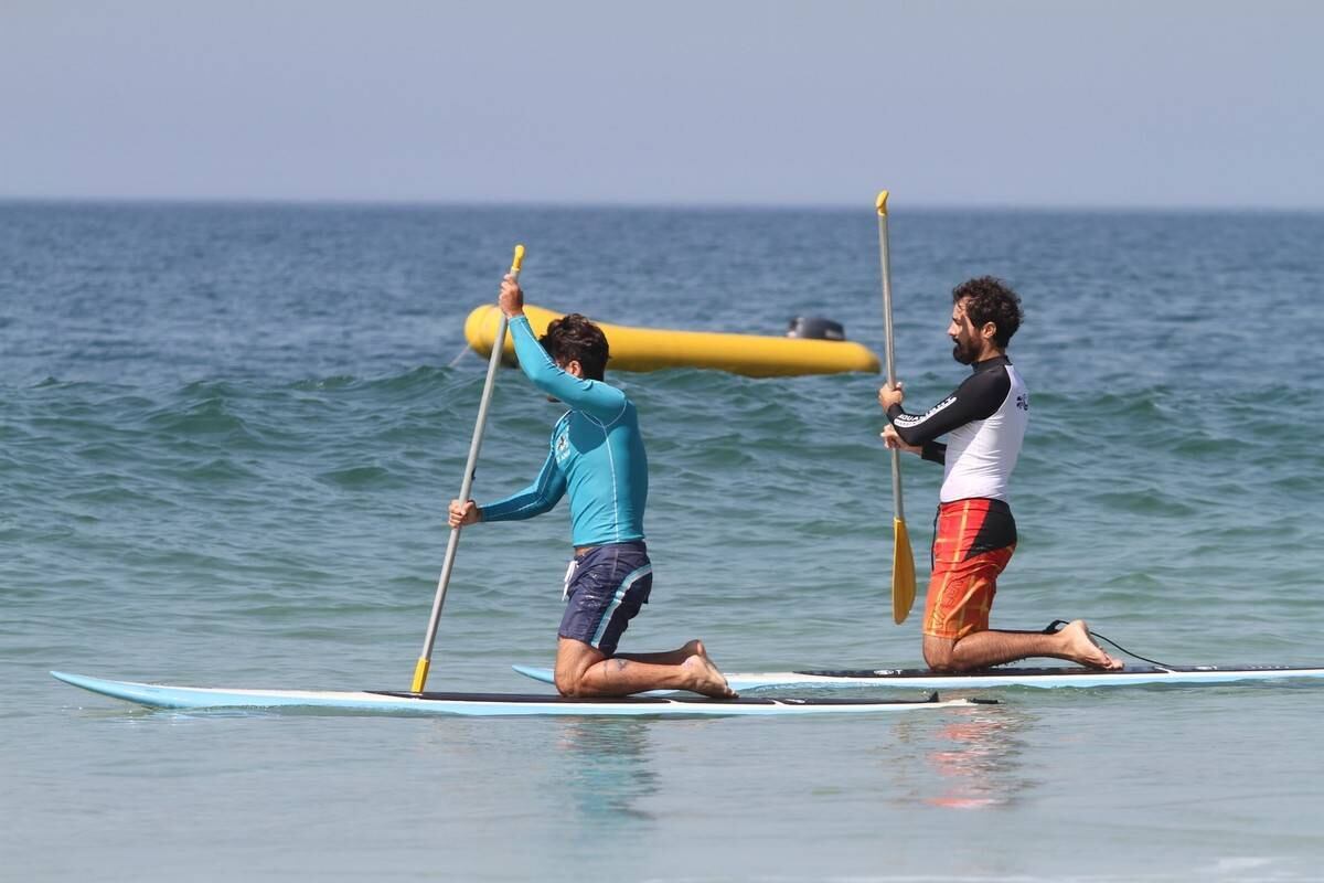 Bruno Gagliasso e Ricardo Pereira praticam stand up paddle na praia da Barra da Tijuca, no Rio