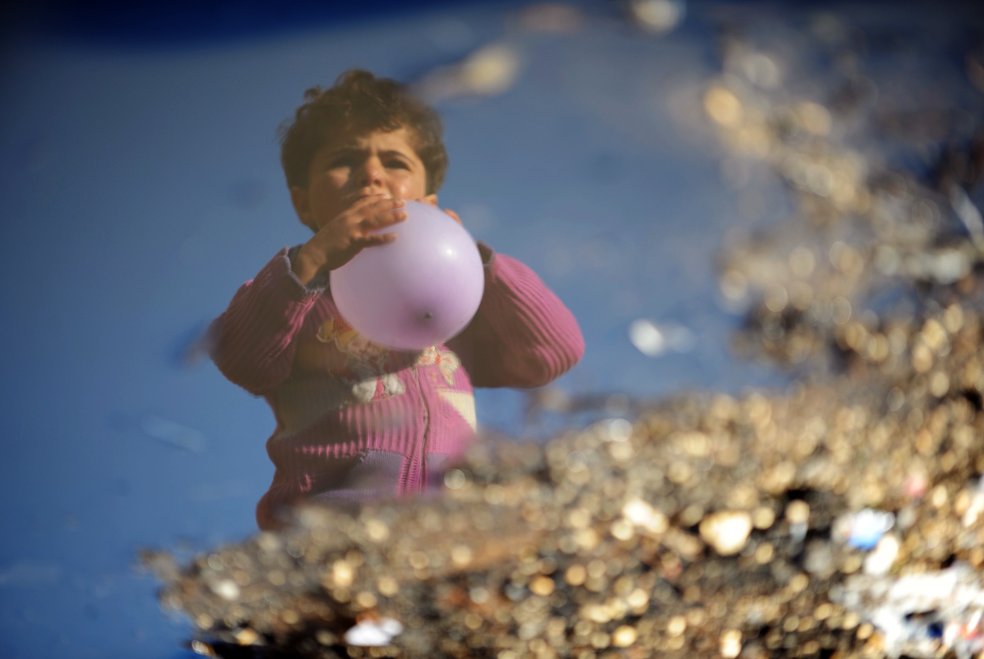 Criança síria refugiada segura um balão no campo de Bab al-Hawa, ao longo da fronteira com a Turquia, na província noroeste de Idlib. O conflito na Síria entre as forças rebeldes e tropas pró-governo matou pelo menos 70.000 pessoas, e forçaram mais de um milhão de sírios a procurar refúgio no exterior