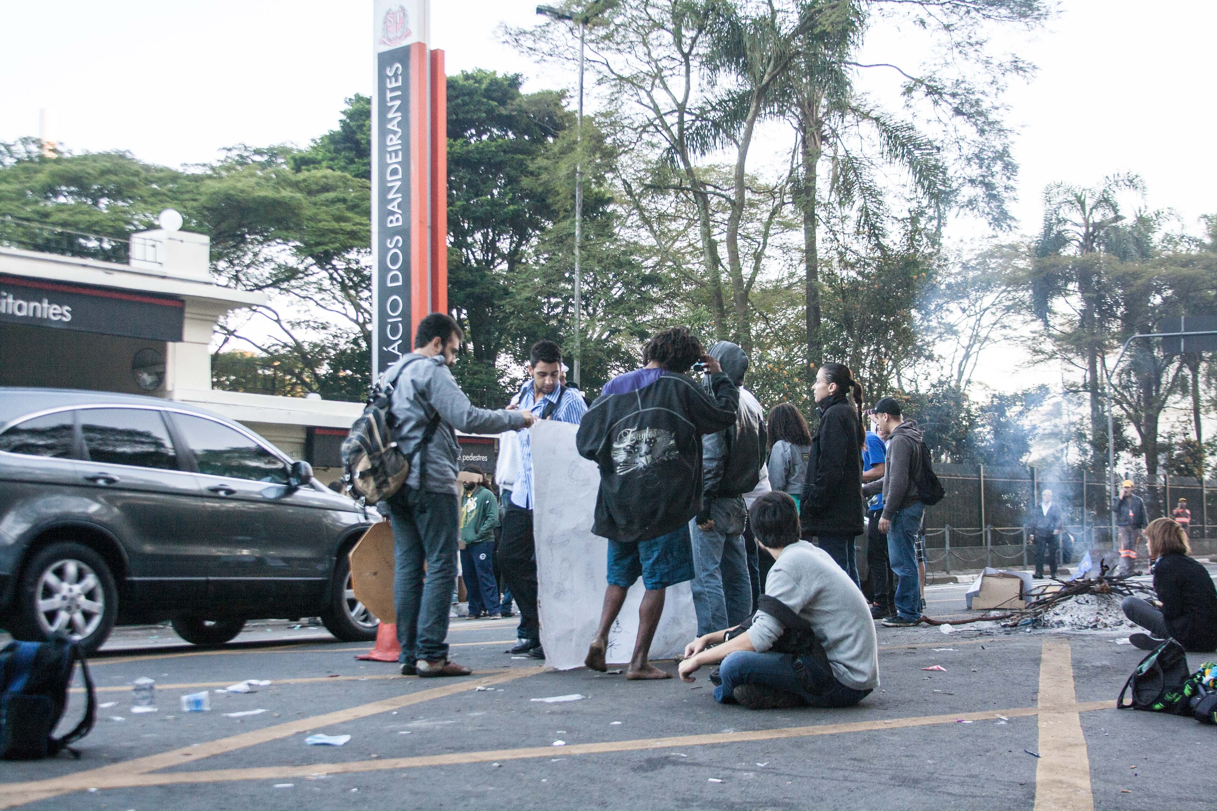 Quatorze horas após o inicio da manifestação contra o aumento das passagens desta segunda-feira (17) ao menos 20 manifestantes continuavam em frente ao portão 2 do Palácio dos Bandeirantes, na zona oeste de São Paulo, na manhã desta terça (18). Eles exibiam placas, cartazes e fizeram uma fogueira