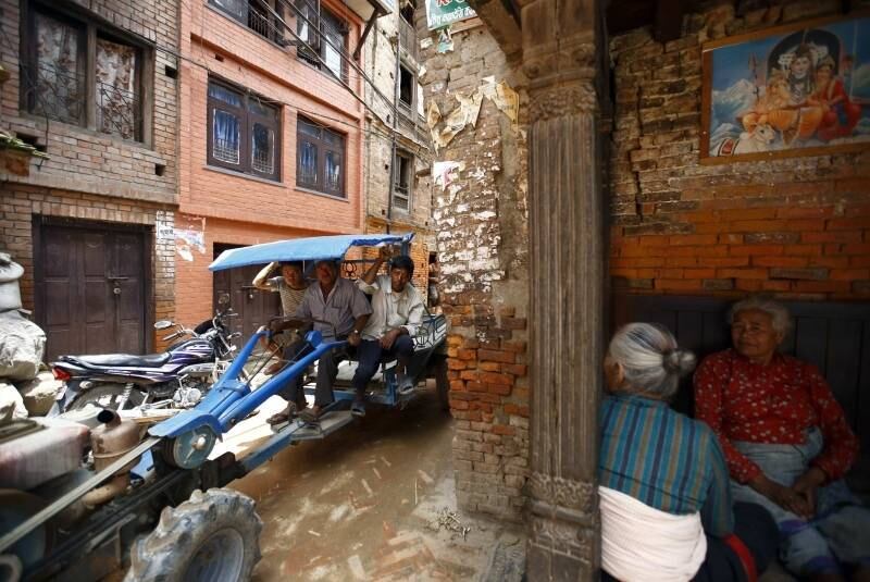 Nepaleses andam de trator pelas ruas da cidade antiga de Bhaktapur, próxima a Catmandu,
capital do Nepal 
