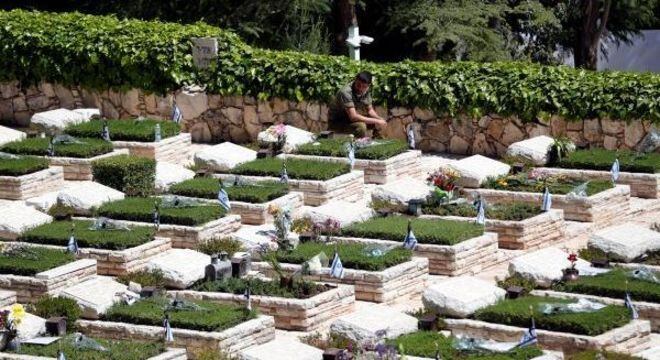 Tropas com máscaras cirúrgicas se filmaram batendo continência junto aos túmulos