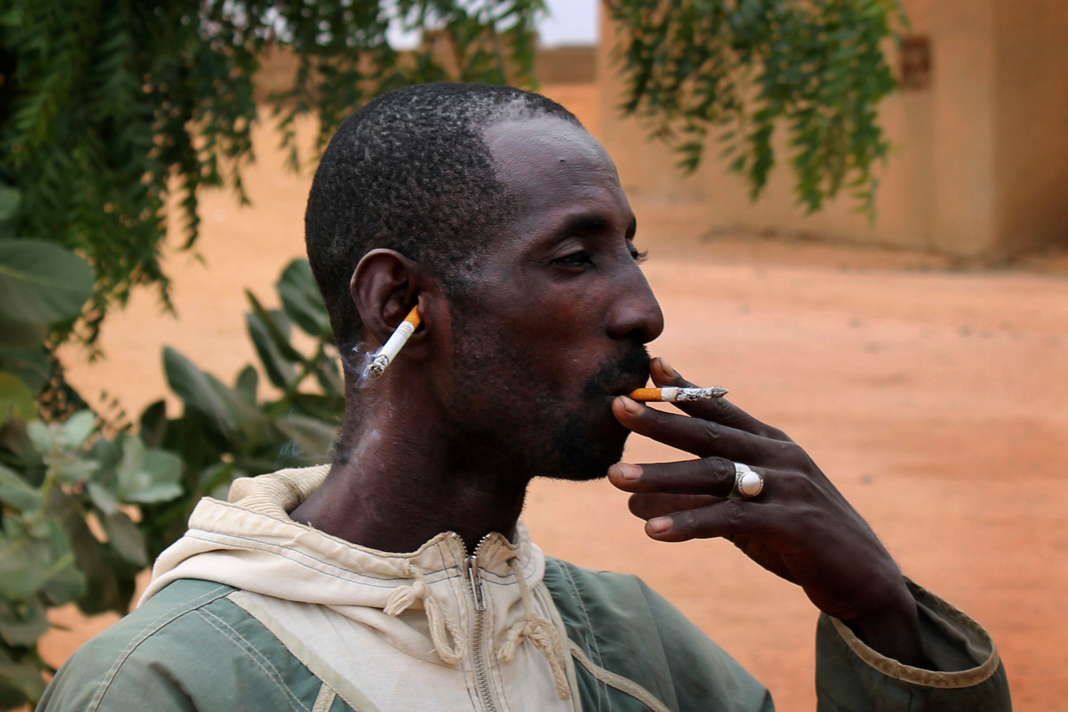 Homem fuma para celebrar a chegada das tropas francesas e malinesas em Gao, no Mali. O grupo radical islâmico MUJAO, que havia tomado a cidade antes da chegada das tropas, tinha proibido o uso de cigarros, de acordo com sua interpretação da lei islâmica