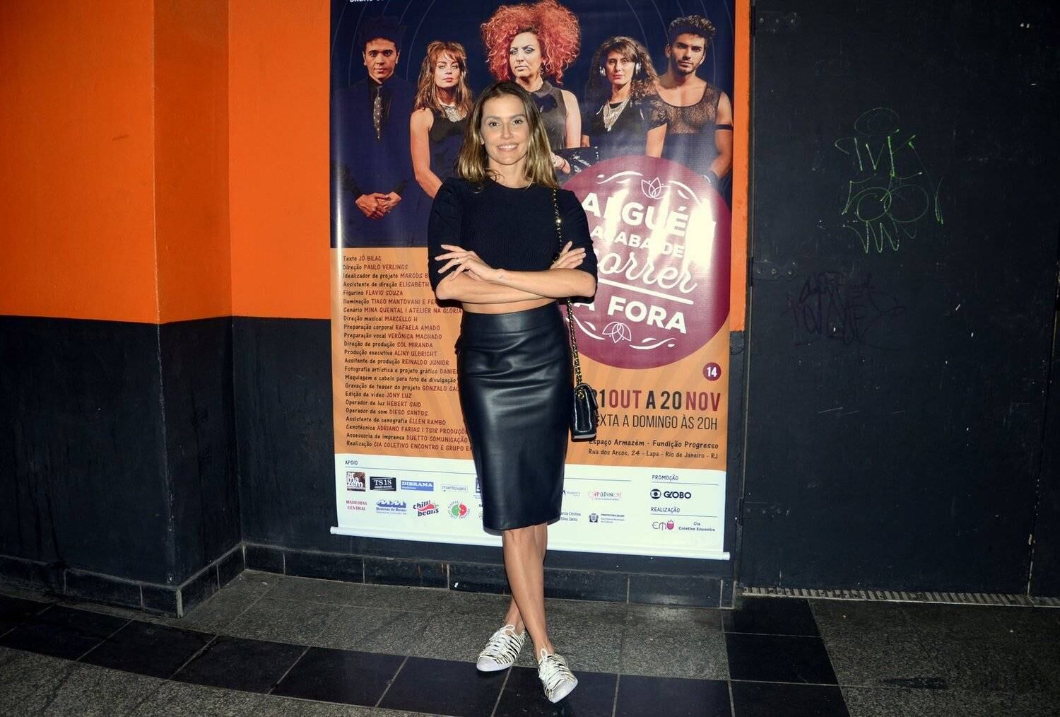 Deborah escolheu um look composto por uma blusa preta cropped, deixando a barriguinha de fora, e uma saia também preta, um pouco abaixo dos joelhos