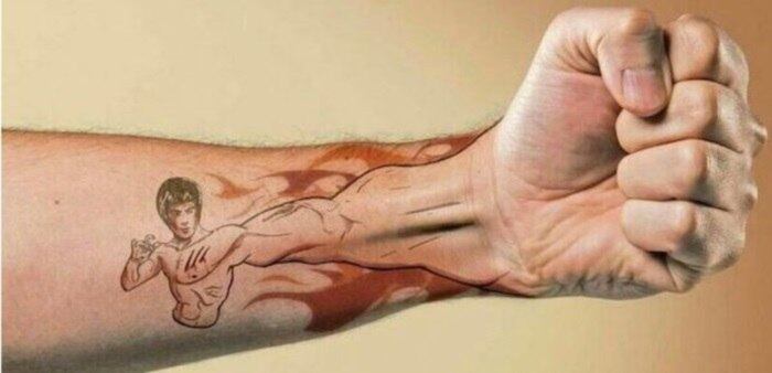 O especialista em artes marciais, Bruce Lee, foi desenhado no antebraço desse sujeito