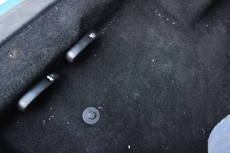 Alavancas de abertura do porta-malas e tanque de combustível estão no assoalho à esquerda do motorista