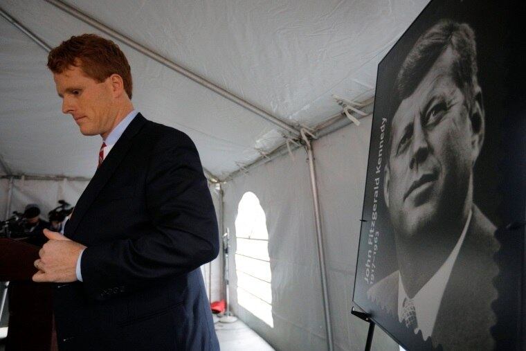 Joe Kennedy III, ao lado de um cartaz com a foto do tio-avô