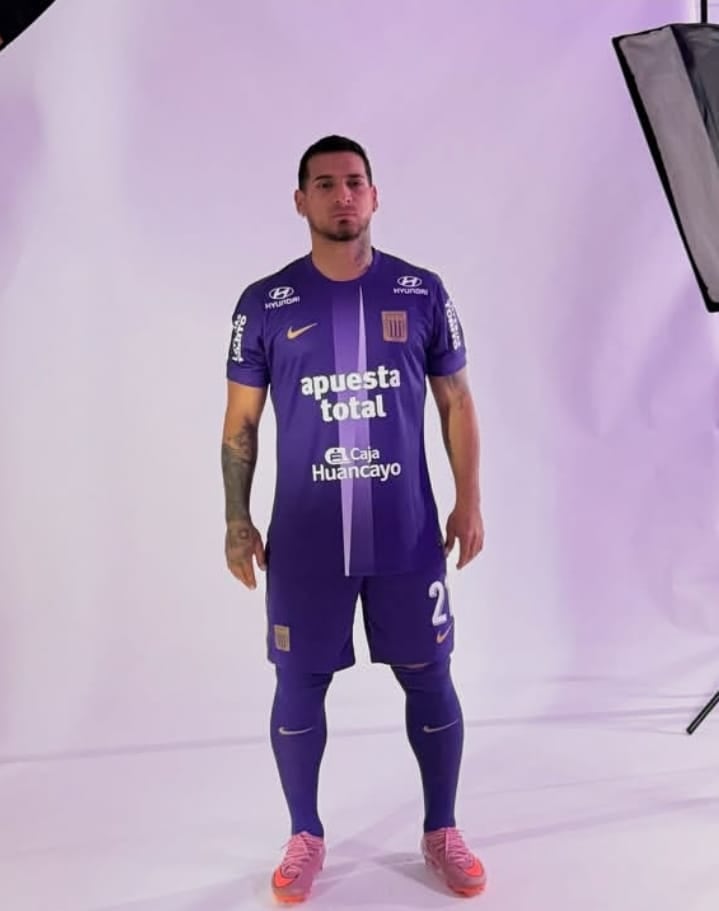 O jogador de futebol Miguel Trauco participa de uma sessão de fotos vestindo uma camisa do time Alianza Lima