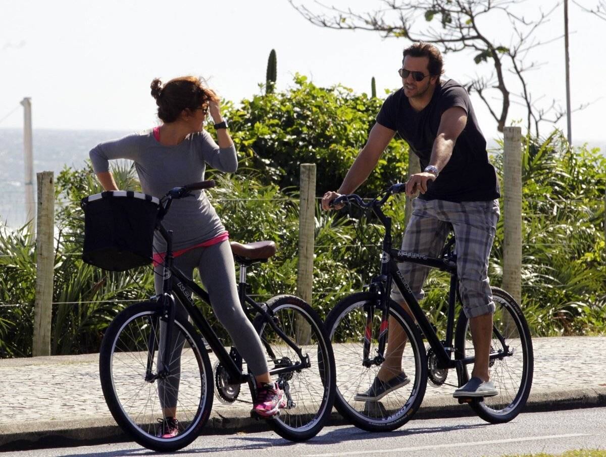 Adriana Esteves e Vladimir Britcha andam de bicicleta na praia da Barra, no Rio