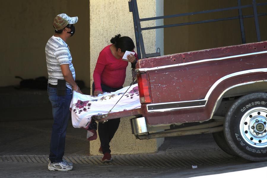 Familiares aguardam que serviço funerário retirem corpo de parente que morreu de covid-19 antes de chegar ao hospital em Ciudad Juarez, México