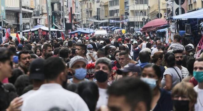 Pedestres lotam a 25 de Março, na região central de São Paulo, neste sábado (10)