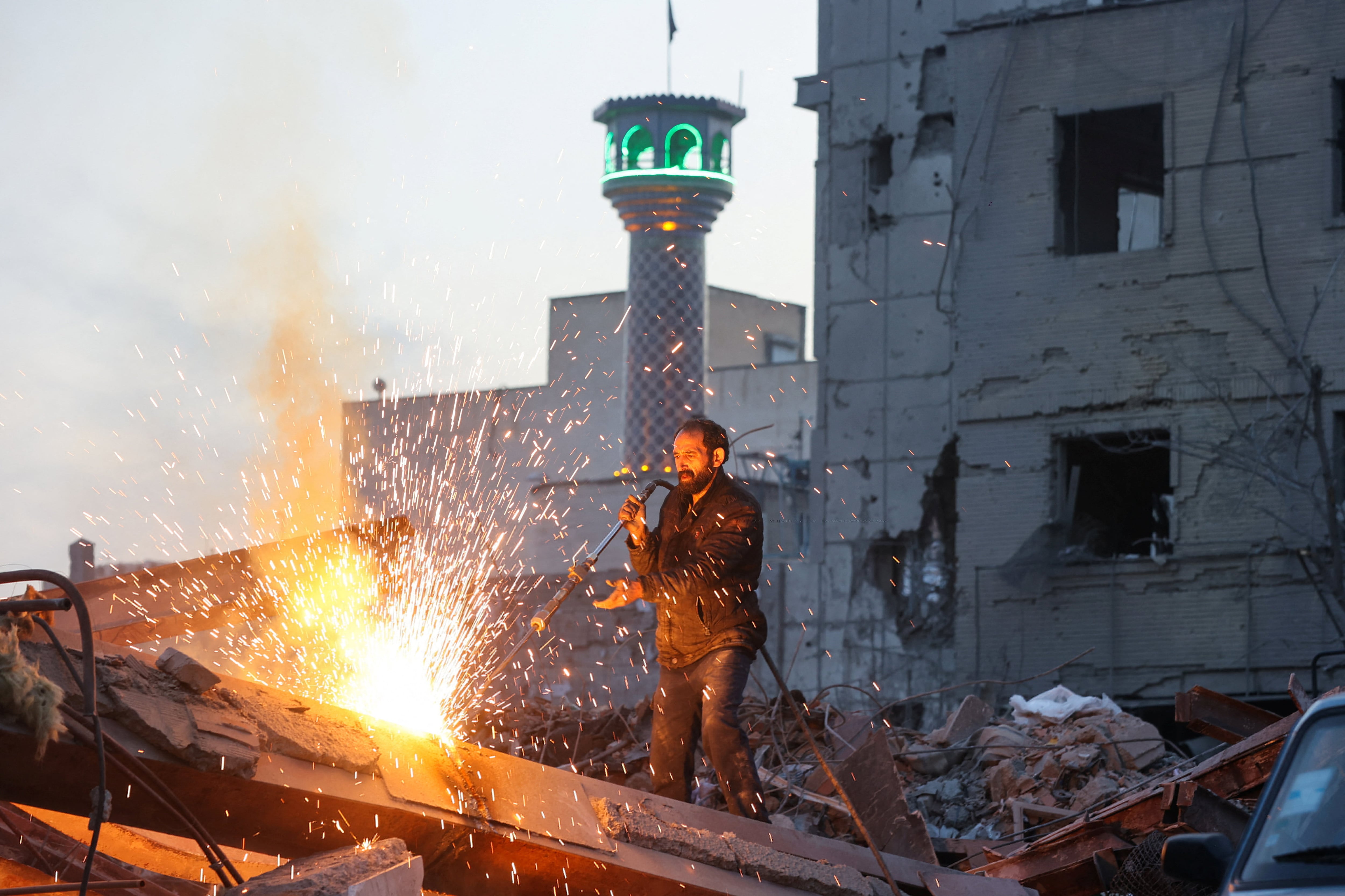 Um homem trabalha em meio aos escombros, após um ataque conjunto de Israel e dos EUA a uma delegacia de polícia, em meio ao conflito entre EUA e Israel com o Irã, em Teerã, Irã