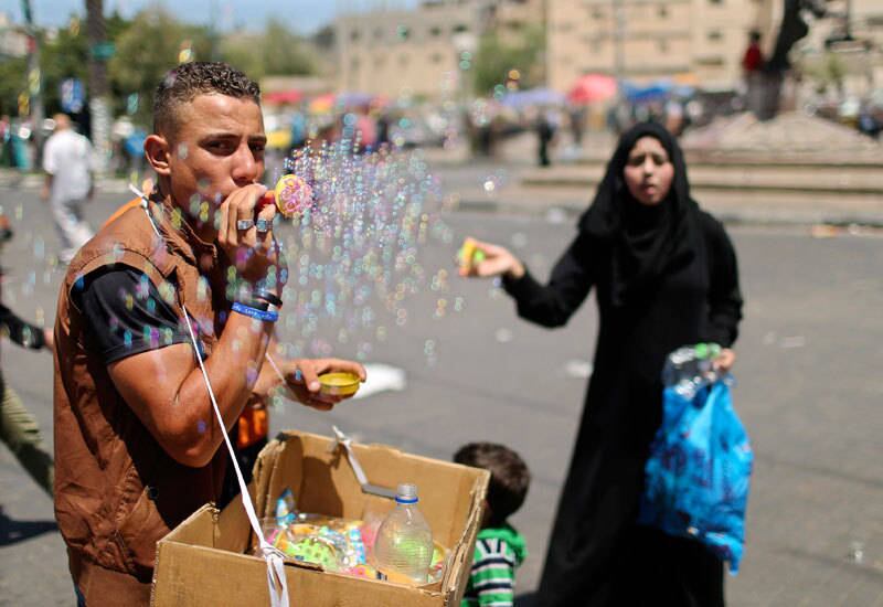 Vendedor de brinquedos faz bolas de sabão nas ruas de Gaza nesta quinta-feira (1º)