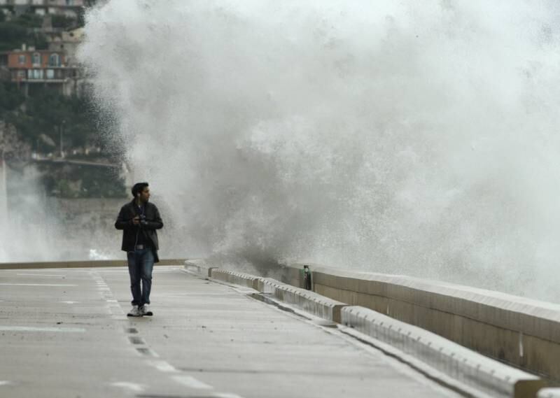 Mesmo grandes cidades como Nice, na França, sofrem com as constantes ondas fortes na zona costeira. Mas o homem acima, com sua máquina e fones de ouvido, parece não ligar muito para o perigo