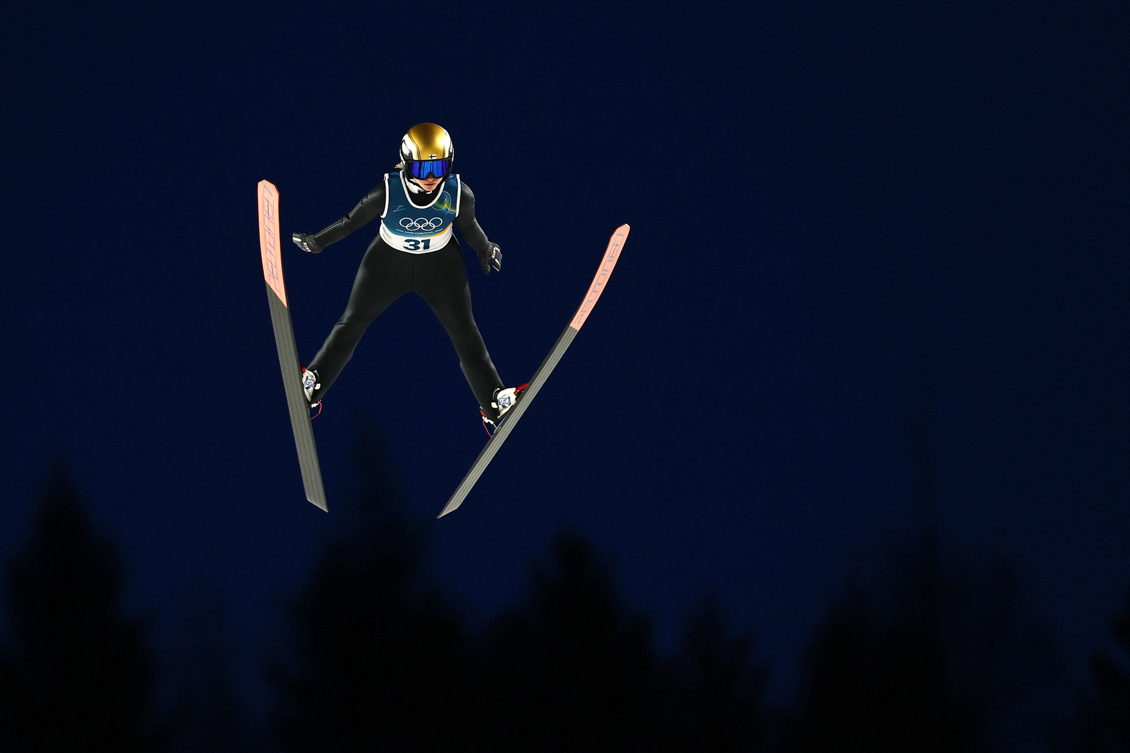 Jenny Rautionaho, da Finalândia, suspensa no ar durante rodada teste de salto de esqui