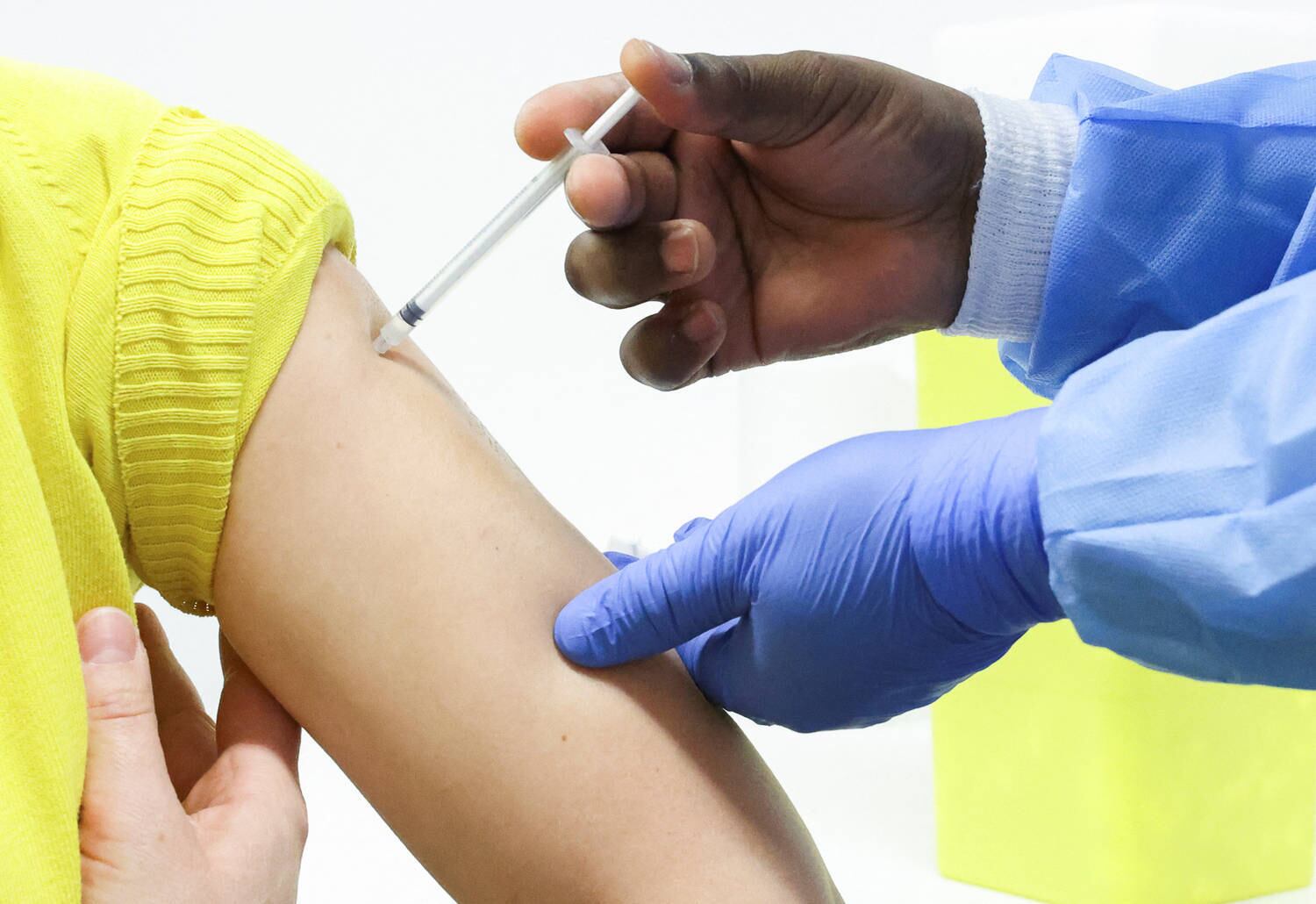 A woman receives a booster dose of Pfizer's coronavirus disease (COVID-19) vaccine at a vaccination centre in Brussels, Belgium, January 5, 2022. REUTERS/Yves Herman