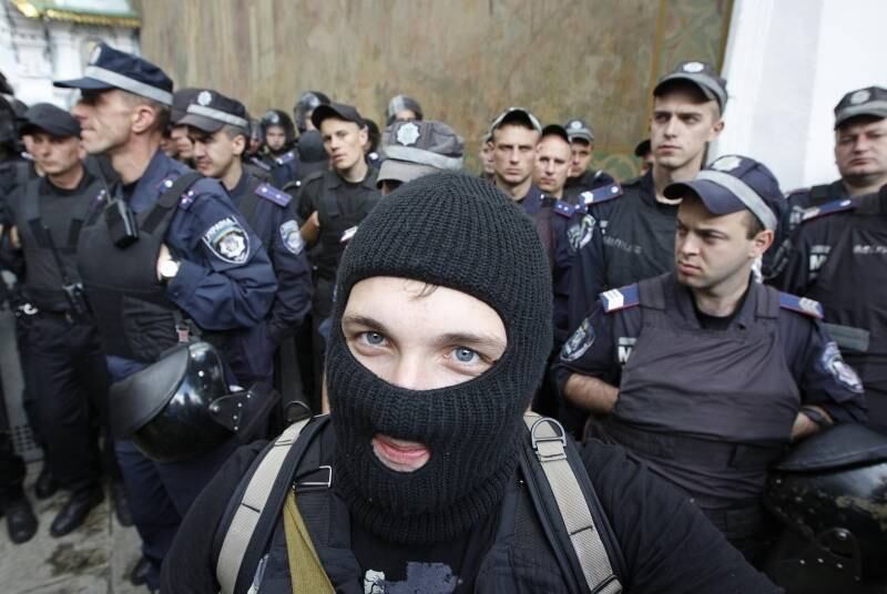 Manifestante usando uma
balaclava se posiciona perto das forças de segurança do ministério ucraniano do
Interior durante protesto pró-Ucrânia e anti-separatista em Kiev