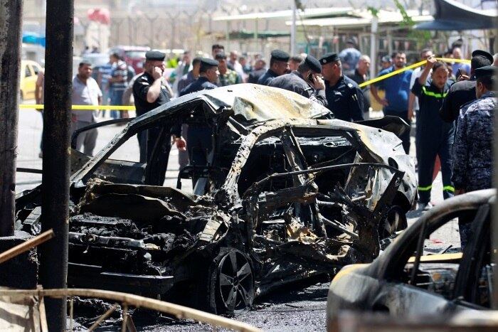 Destroços de um veículo em local de ataque com carros-bomba em Bagdá, no Iraque